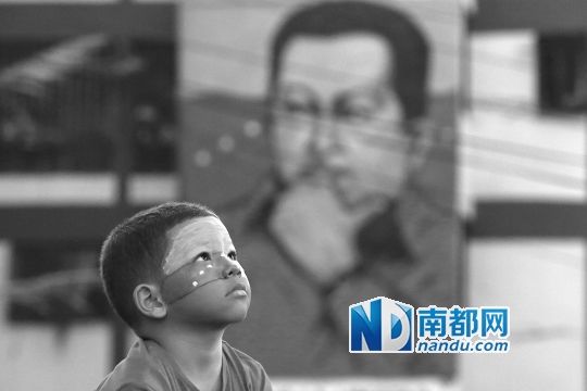 3月5日，一名委內(nèi)瑞拉兒童仰望天空，他身后是查韋斯的陵墓。