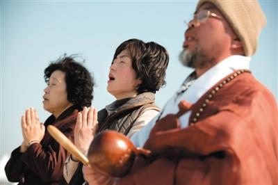 23日，一名僧侶引領(lǐng)人們?yōu)樗勒咂矶\。