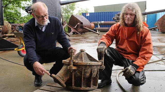 丹麥潛水員安德森（左）展示其打撈上來的U-78潛艇殘骸。