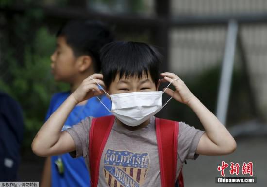 圖為當?shù)貢r間2015年6月8日，韓國未停課的學(xué)校，學(xué)生課前戴口罩測體溫。