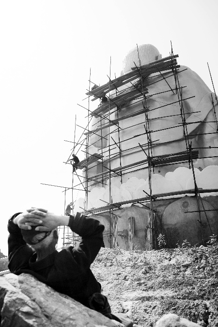 今年4月26日，工作人員將帆布蓋在“佛像”頭像上