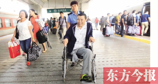 李剛手術(shù)后歸來，在車站工作人員幫助下走出鄭州火車站站臺(tái)  東方今報(bào)首席記者 張曉冬 攝