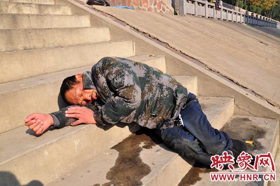 這名男子的衣服以及褲子全濕透了，水從衣褲里流出來，嘴里散發(fā)著濃烈的酒氣。