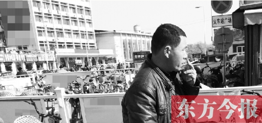 一男子在開(kāi)封火車站售票廳外吸煙