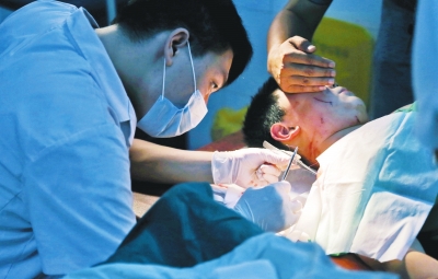 孩子身上有7道傷痕，其中兩道需要縫合，其他的均為擦傷，醫(yī)生正對(duì)他施治。