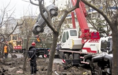 輸油管道爆炸后，搶修人員將被炸毀的車輛運(yùn)出現(xiàn)場(chǎng)。