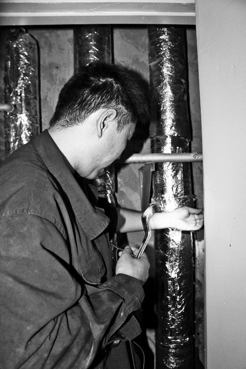 苗師傅一邊進行維修，一邊用耳機接聽市民的電話。