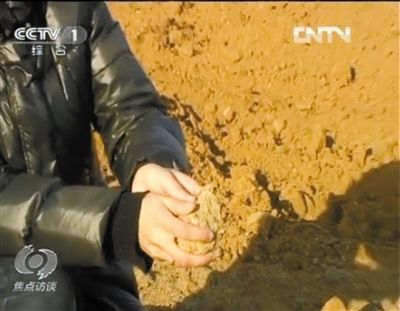 麻剛沙系麻剛石粉碎而成。記者找到一塊麻剛石，一捏就碎成粉末，硬度非常差。央視截圖