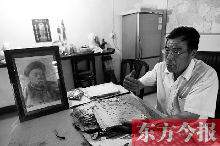 　魏樹紹手拿《物權(quán)法講義》手稿，在講訴先祖書寫“物權(quán)法”的歷史（相框里就是魏聯(lián)奎）