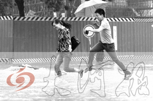 鄭州經(jīng)三路與北環(huán)交叉口處，積水較深，行人們不得不“練輕功”。 記者 白周峰 攝影