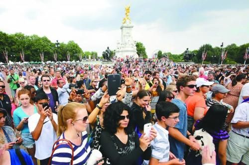 7月23日，在英國倫敦白金漢宮外，民眾們爭相閱讀“王室寶寶”出生的正式公告。