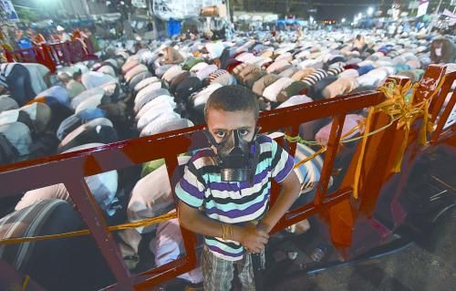 當(dāng)?shù)貢r(shí)間28日晚，在埃及開(kāi)羅納賽爾城，一名小男孩頭戴防毒面具參加穆兄會(huì)的集會(huì)示威。