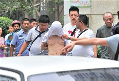 昨日，成都警方抓捕時與毒犯發(fā)生槍戰(zhàn)。一名男犯罪嫌疑人被警方押出。