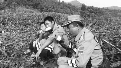 饑餓難忍，中國緊急救援河南基地的救援隊(duì)員在已毀的玉米地里撿拾生玉米吃。