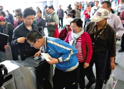 去年5月5日，14號(hào)線園博園站，乘客刷卡出地鐵。北京公交地鐵將實(shí)行計(jì)程票制，多乘坐多付費(fèi)。