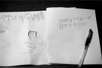 名叫袁明燕的小姑娘用筆在紙上不斷寫“媽媽”二字。