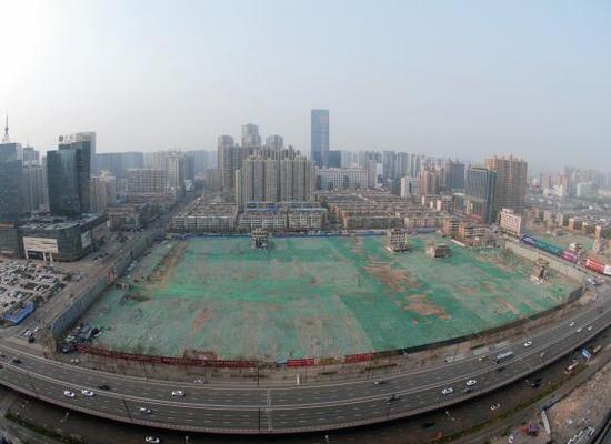 2016年4月，經(jīng)過持續(xù)攻堅，親賢社區(qū)西北片區(qū)的拆遷工作基本告一段落，但在鋪設了防塵綠網(wǎng)的空地中，至今仍有3戶居民選擇了“堅守”。(拍攝：2016年4月4日)