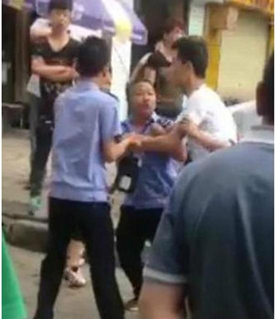 付某（右）與城管執(zhí)法人員廝打在一起。