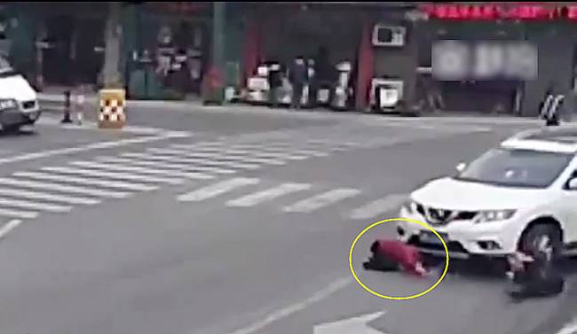 圖為小姑娘被卷進(jìn)車輪下瞬間。