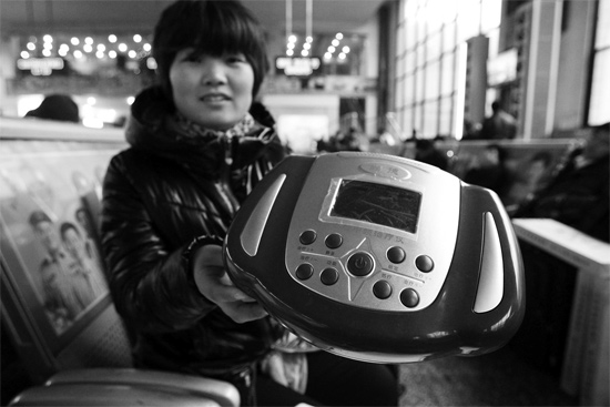 火車站候車室，李女士向記者展示她準備孝敬父母的按摩儀