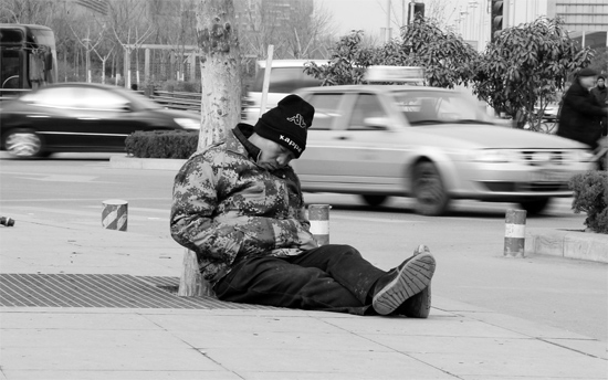 2月2日，鄭州市中州大道農(nóng)業(yè)路立交橋下，50歲的王文德打算在臨近春節(jié)前再接些零活兒，由于疲憊，他睡著