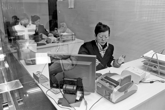 2月16日，鄭州市自來水總公司鄭東新區(qū)一營(yíng)業(yè)廳，柜臺(tái)內(nèi)工作人員正在為市民辦理業(yè)務(wù)