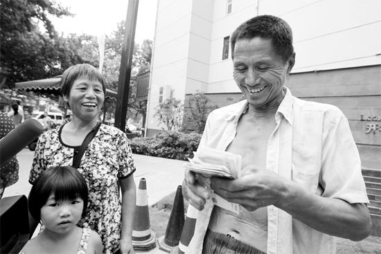 昨日，鄭州市明達(dá)路與豐慶路交叉口西300米路南，來自中牟的瓜農(nóng)拿到西瓜款，笑開顏東方今報(bào)記者袁曉強(qiáng)