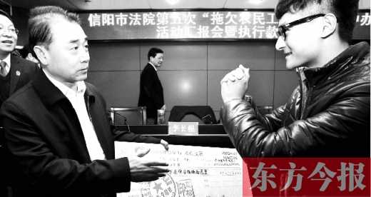 張立勇將依法執(zhí)行回來的農(nóng)民工工資發(fā)放給案件當(dāng)事人游昌華，游昌華施以中國(guó)傳統(tǒng)作揖禮答謝