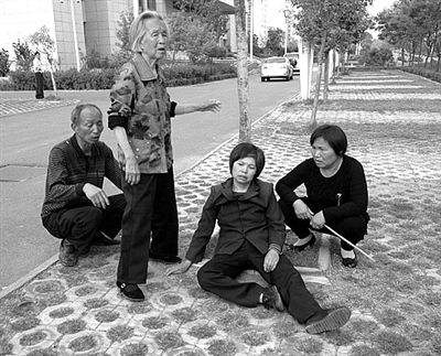 2013年4月28日，平頂山市市政府附近，受害者郭小蕊（化名）的家屬鳴冤，郭小蕊的母親杜玉花癱坐在地上。