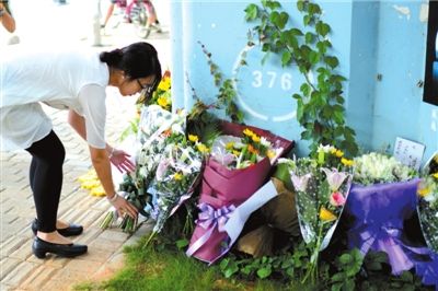 6月8日下午，記者來到廈門公交車爆炸事發(fā)現(xiàn)場橋下，附近已聚集了十幾個自發(fā)前來悼念的市民。橋墩下排放了一圈或黃或白的菊花，還有玖瑰、百合等。