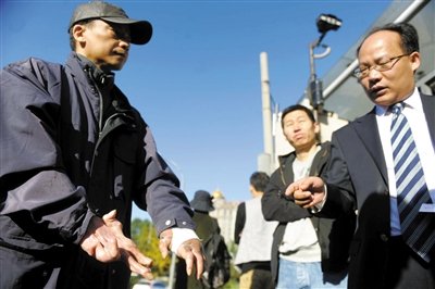 常林鋒在法院外展示雙手，他稱被燙傷的手因刑訊逼供且未得到及時救治