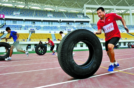 8月15日，運(yùn)動(dòng)員們正在進(jìn)行推輪胎賽跑。