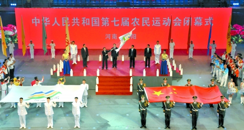 南陽市市長穆為民將農(nóng)運會會旗遞交到下一屆東道主吉林省松原市市長李相國手里。