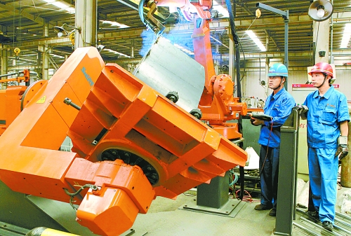 圖為龍工集團中原公司的職工正在操作機器人焊接裝載機。