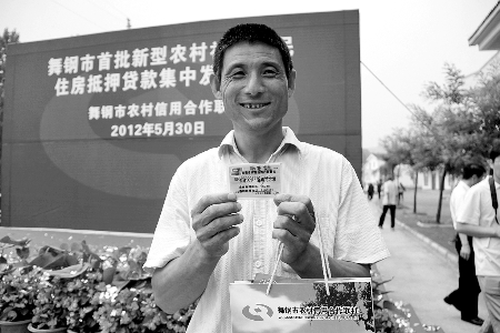 領(lǐng)到貸款，農(nóng)民開心地笑了。