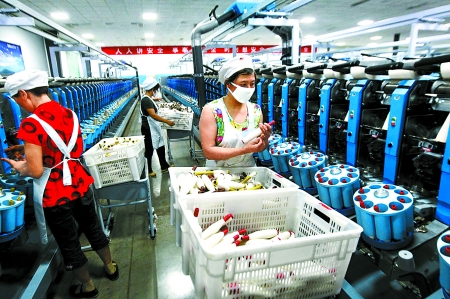 6月6日，舞鋼市鑫海紡織有限公司員工正在新建成的紡紗車間生產(chǎn)。