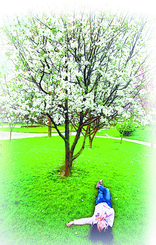 　孩子愜意地躺在社區(qū)內(nèi)的草坪上。