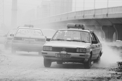 施工的道路上，車輛通過塵土飛揚(yáng)。
