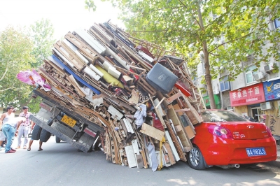 紅色小轎車被砸，卡在路邊動(dòng)彈不得。