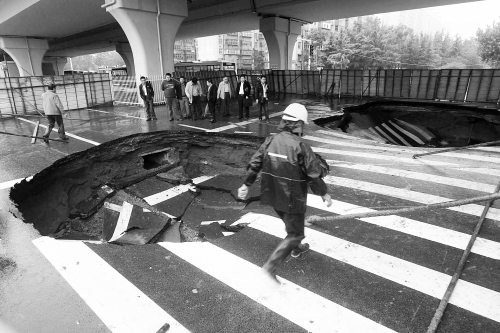 中原路西三環(huán)立交橋下由南向北原本4個(gè)車道，由于塌坑，而今3個(gè)車道被圍擋