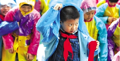 昨日下午,農(nóng)科路上一小學放學時,孩子們大部分都穿著雨披。