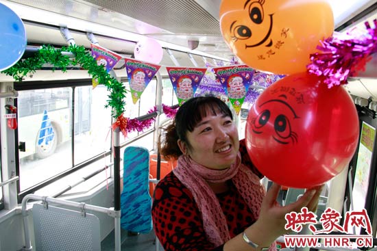 鄭州快速公交B3區(qū)間線車長李鵬云在車廂里懸掛氣球，布置圣誕車廂，營造歡樂圣誕氛圍