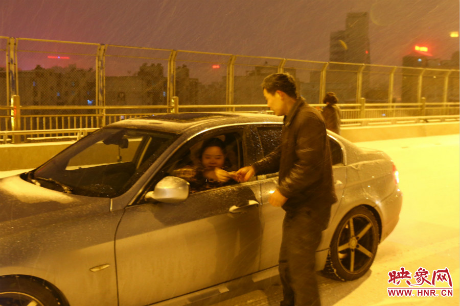 “推車人”幫助一輛車上坡后，收取“勞務(wù)費(fèi)”。