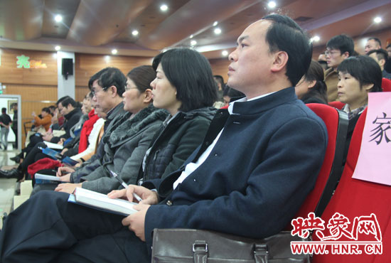認(rèn)真聽取招生政策的學(xué)生家長。