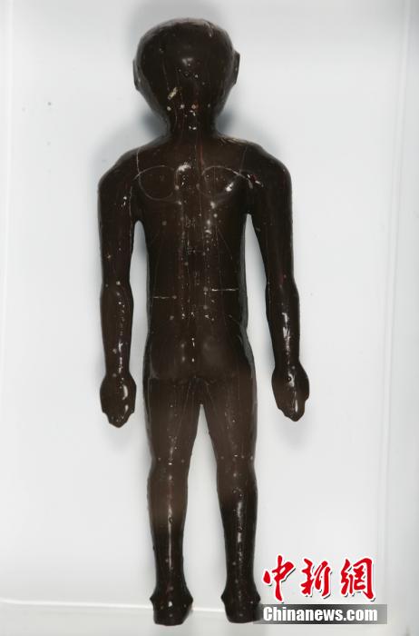 圖為出土的人體經(jīng)穴漆俑。