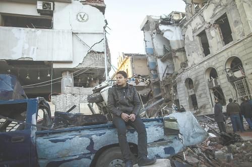 埃及曼蘇拉市警察局24日遭汽車炸彈襲擊，被疑是穆兄會的報復。圖為一名男子在被炸毀的警察局前。