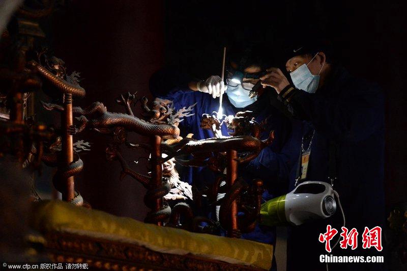 圖為工作人員使用軟毛刷和吸塵器對(duì)太和殿的金漆雕龍寶座除塵。
