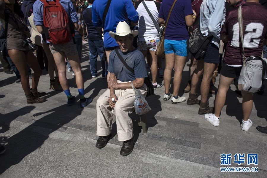 一名男子坐在參加不穿褲子搭地鐵的人群邊小憩。