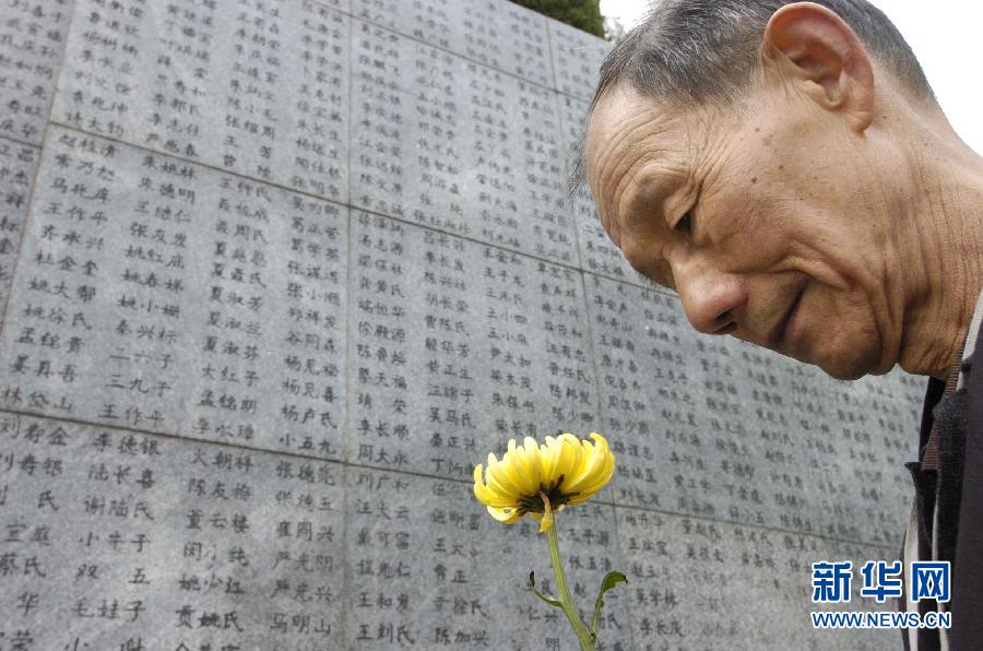 2006年4月5日，74歲的南京大屠殺幸存者佘子清手捧鮮花，祭奠被日軍殺害的母親。