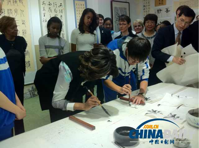 　北京時(shí)間3月21日，美國(guó)第一夫人米歇爾參觀北師大二附中時(shí)，與學(xué)生一起練習(xí)書法。